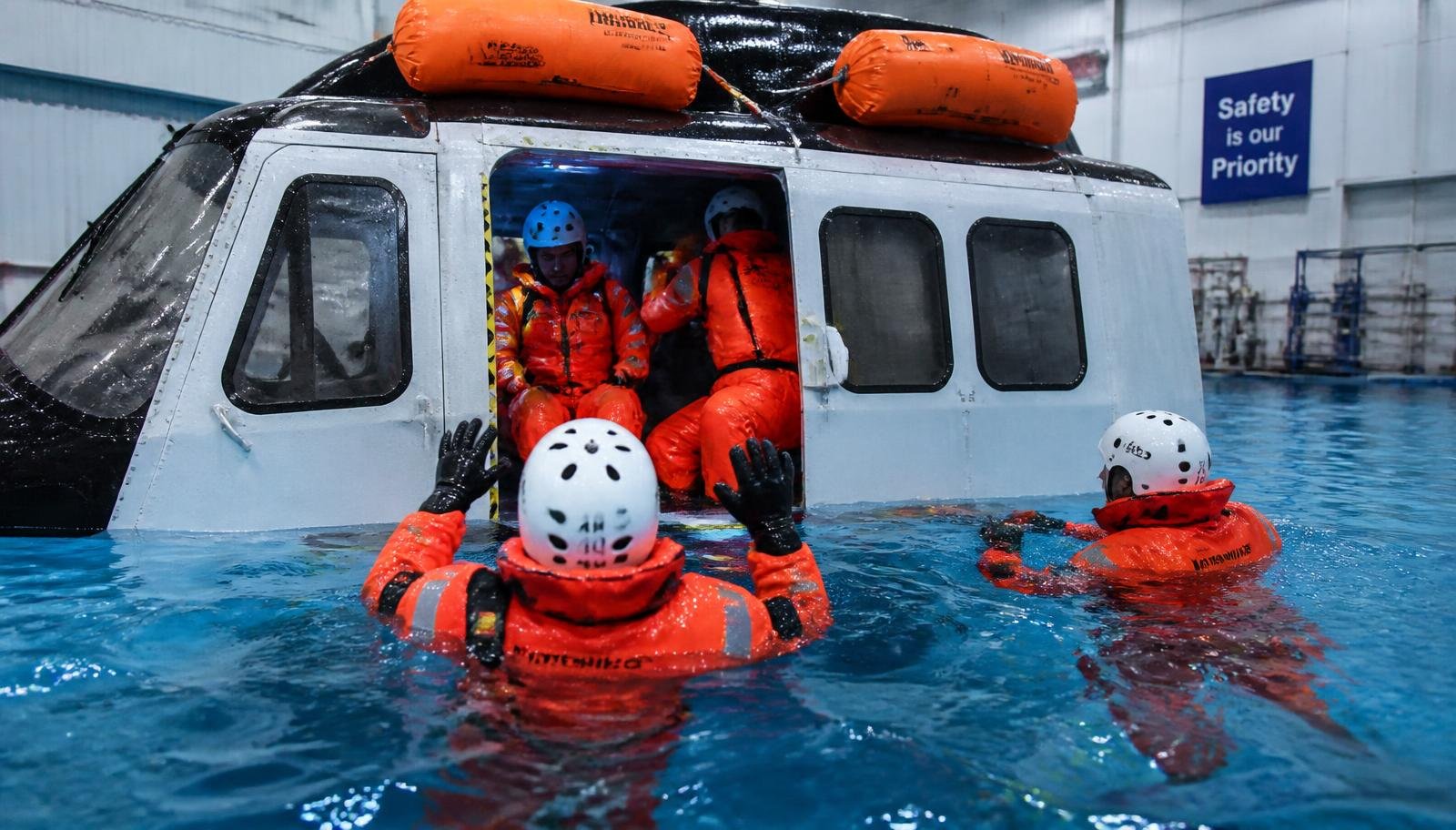 Offshore workers in survival suits during BOSIET helicopter underwater escape training
